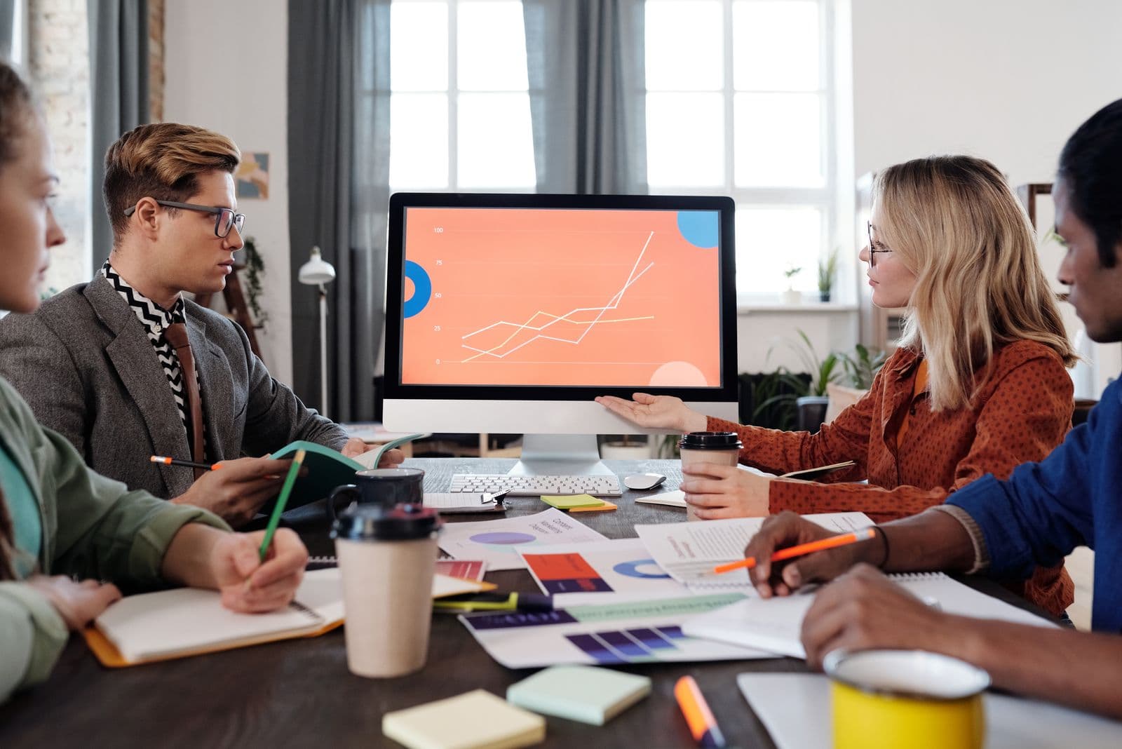 A team reviewing business performance data on a screen while making an investment decision