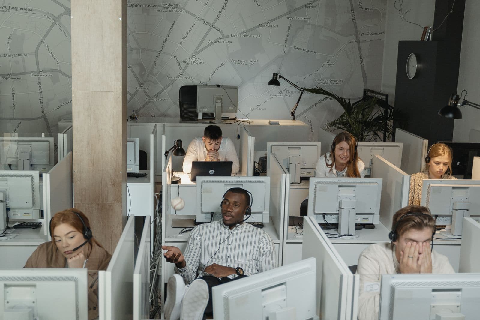 A customer support team working at desks with headsets in a busy call center