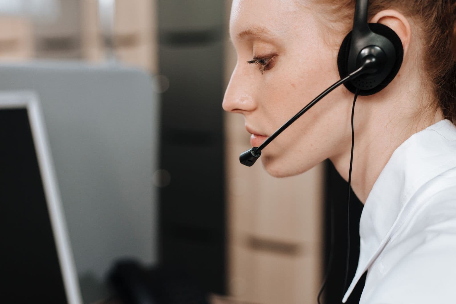 A customer support agent wearing a headset in a contact center, with AI handling first-line triage