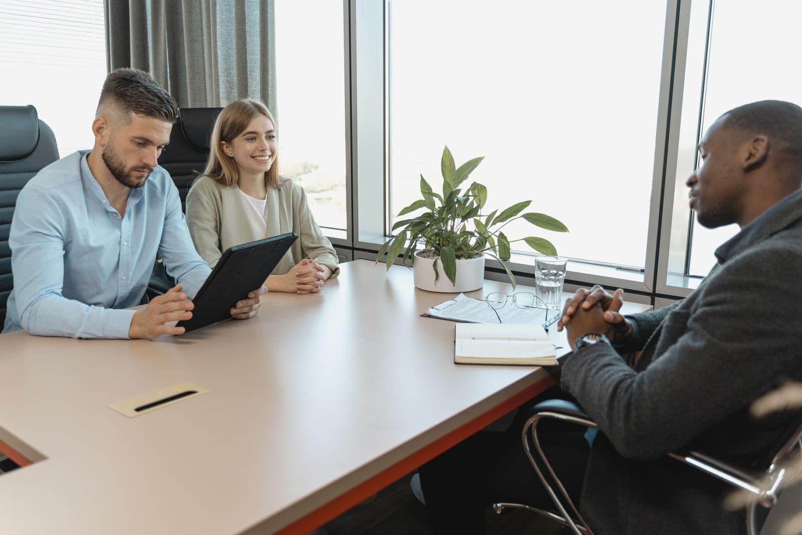 A hiring manager interviewing a candidate across a table in a bright meeting room